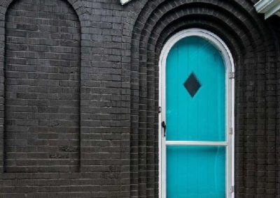 black-brick-home-exterior-with-bright-blue-accent-door